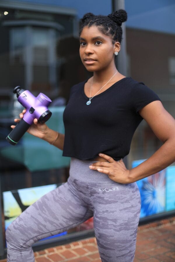 women athlete holding total massage gun