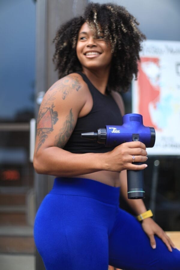 women athlete holding total massage gun