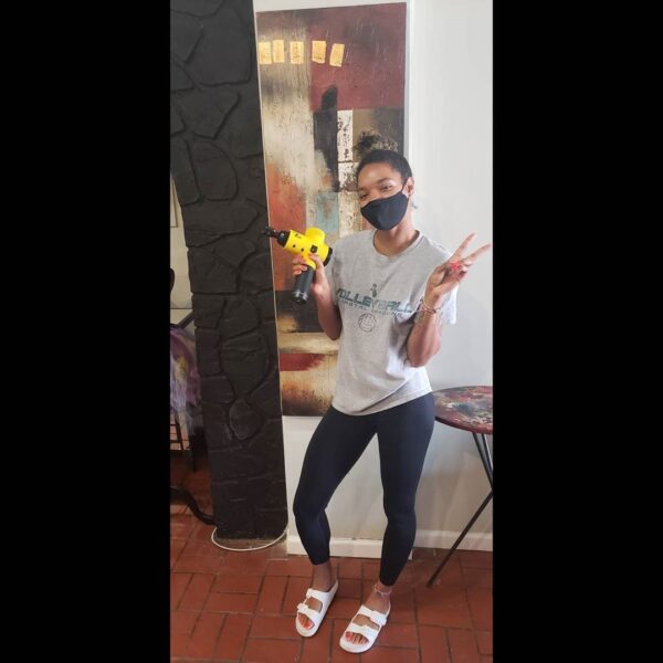 women athlete holding total massage gun