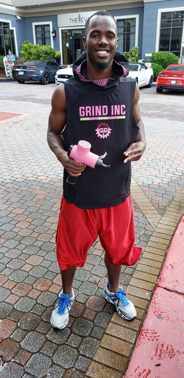 athlete holding total massage gun